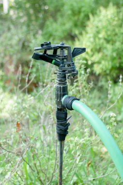Sprinkler head close up over the green grass