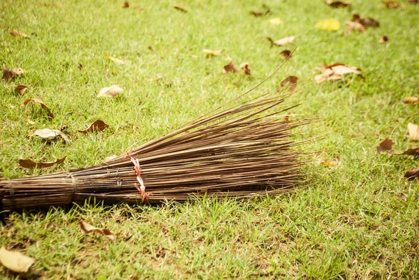 在秋天的长凳叶区域附近的扫帚。从公园秋叶清理花园. — 图库照片