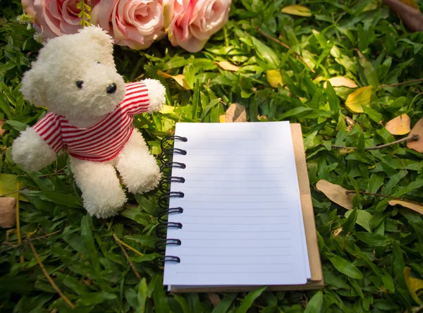 Notebook com ursinho de pelúcia e rosas no jardim, abstrato efeito digital para fundo — Fotografia de Stock