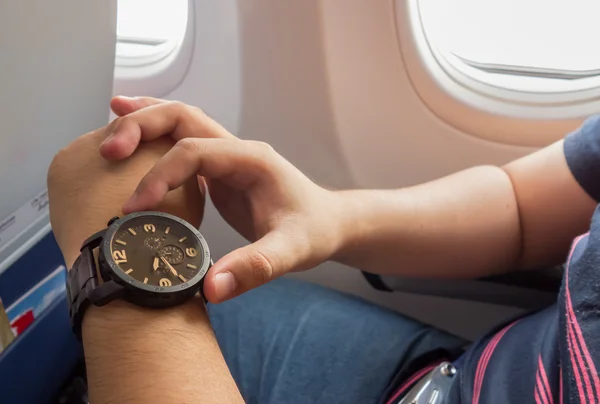 El hombre que mira el reloj en el avión para el concepto de período urgente — Foto de Stock