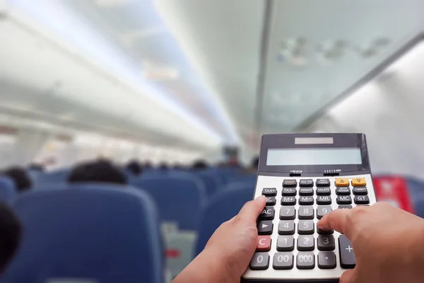 Concepto de cálculo de costes de viaje por calculadora y cabina de avión en segundo plano — Foto de Stock