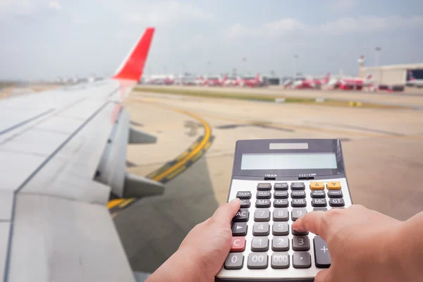 Concepto de cálculo de costes de viaje por calculadora y avión en segundo plano — Foto de Stock