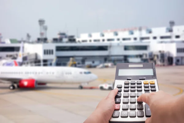 Concepto de cálculo de costes de viaje por calculadora y avión en segundo plano — Foto de Stock