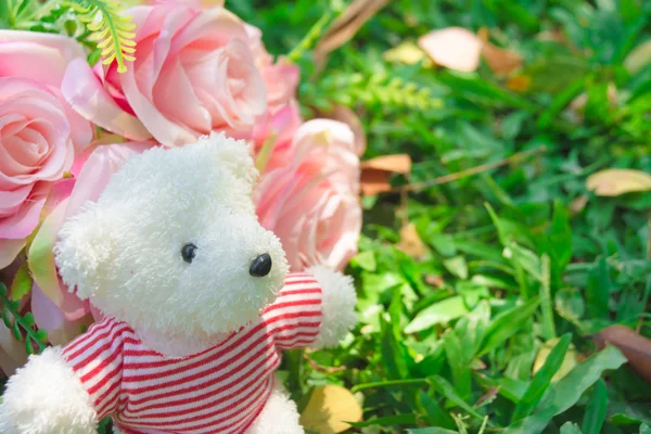 Urso de pelúcia com coração e rosas no fundo — Fotografia de Stock