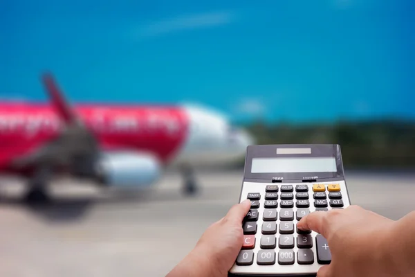 Concepto de cálculo de costes de viaje por calculadora y avión en segundo plano — Foto de Stock