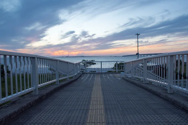 Wunderschöner Pier im Sonnenuntergang, dramatischer lila und blauer bewölkter Himmel — Stockfoto