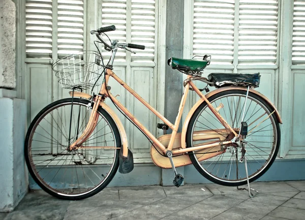 A bicicleta vintage e a parede de madeira no chão de suporte — Fotografia de Stock