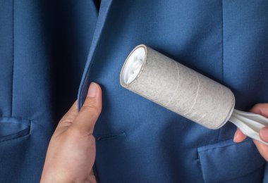 Kuru Temizleme ve iş Tema: Mavi takım elbise ve mobilya toz temizlik için beyaz bir yapışkan fırça tutan adam yardım