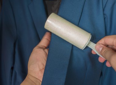 Kuru Temizleme ve iş Tema: Mavi takım elbise ve mobilya toz temizlik için beyaz bir yapışkan fırça tutan adam yardım