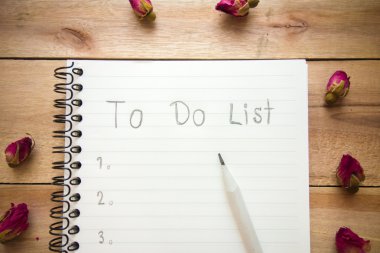 Defter ile kalem ve gül ahşap zemin üzerinde listelemek için