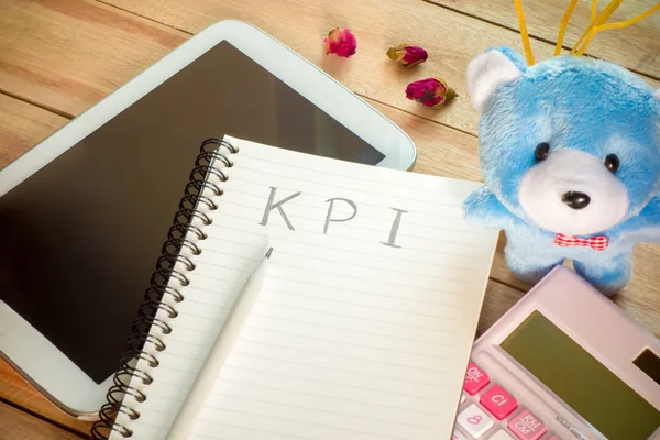 KPI list notebook with tablet calculator pencil on wood floor ,