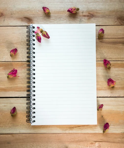 Caderno em branco com espaço de cópia e rosa colocada no chão de madeira — Fotografia de Stock