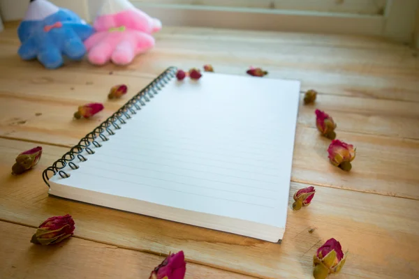 Caderno em branco com espaço de cópia e rosa colocada no chão de madeira — Fotografia de Stock