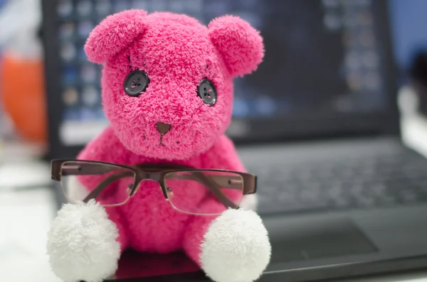 L'ours en peluche avec des lunettes assis sur l'ordinateur portable, effet numérique style vintage — Photo