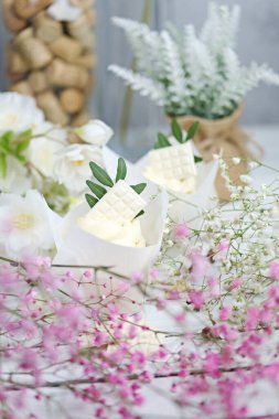 Beyaz ahşap bir masada beyaz tereyağlı kremalı birkaç kek ve kek. Sevgililer Günü ya da Anneler Günü hediyesi. Kırsal biçim.