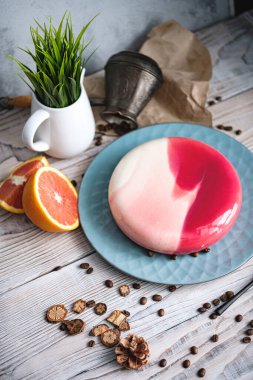 Turuncu dolgulu kırmızı ve beyaz pasta. Siyah bir masanın üzerinde portakallar ve fındıklar var. Kırsal biçim.