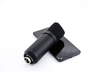 Club Drop-in-in ses kavramı sesle etkinleştirilmiş bir sosyal medya uygulamasıdır. Beyaz arkaplanda akıllı telefon ve mikrofon