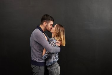Couple of young man and woman standing against of black backgrou