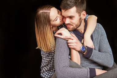 Couple sitting against of black background