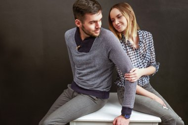 Young man and woman sitting indoors