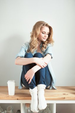 Blonde woman sitting and looking down