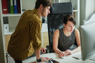 girl working on a computer and the guy next to her