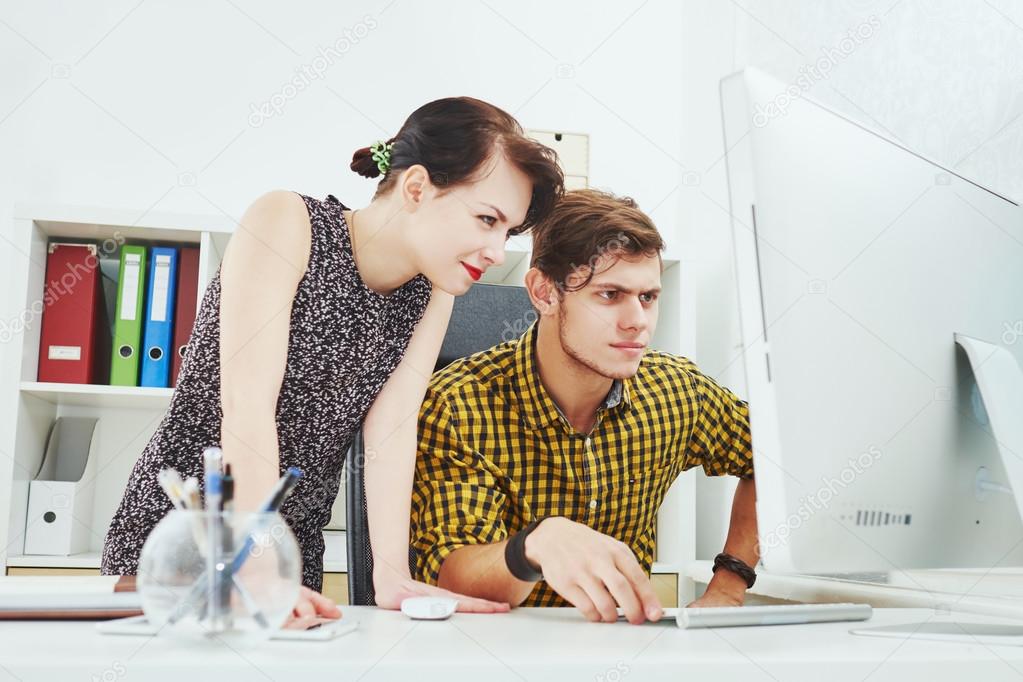 guy working on a computer and the gerl next to him