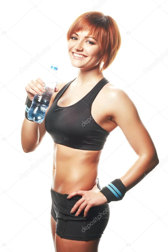 Young fit woman standing and looking at camera with bottle of wa