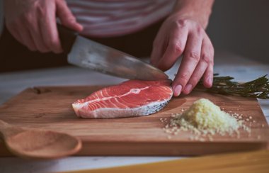 Adamın ellerinin yakın çekim gemide bıçak ile balık kesti.