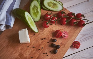 Salata için malzemeler. Biber, çeri domates, zeytin, salatalık, peynir ve tereyağı tahta masada. Rustik Stil.