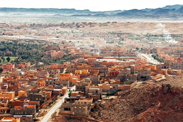 Panorama of berber city of Tinghir in Sahara desert against red canyon and mountains in the background, Morocco