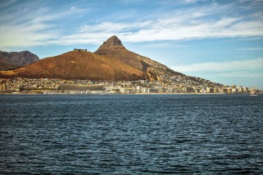 Cape Town liman ve limanının panoramik manzarası, Masa dağı ve aslanlar Güney Afrika, Atlantik Okyanusu 'ndaki turistik bir feribotun tepesine çıkıyorlar.