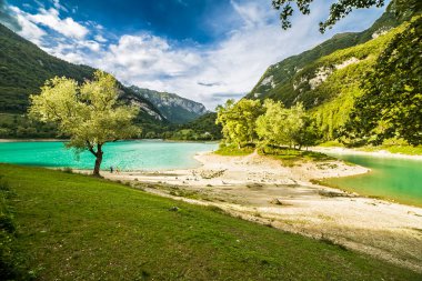 Ağaçlara ve bulutlu gökyüzüne karşı Tenno Gölü manzarası, Riva del Garda, İtalya