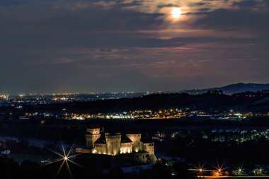Dolu ve bulutlu gökyüzüne karşı Torrechiara kalesinin eşsiz manzarası. Arka plandaki nehir ve şehirde. Parma, Emilia Romagna, İtalya