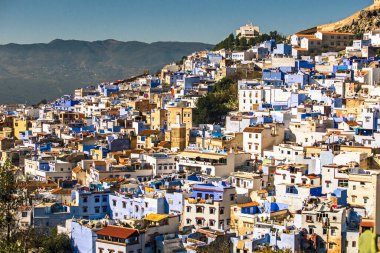Panoramik açıdan mavi ikonik şehir Kasbah ve Medina 'nın açık mavi gökyüzü, zeytin ve dağlara karşı Chefchaouen' ın manzarası. Fas, Afrika
