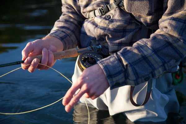 在不列颠哥伦比亚省温哥华市 一名穿着格子花衬衫 拿着钓竿和钓丝在水里涉水的苍蝇渔民的特写镜头 — 图库照片