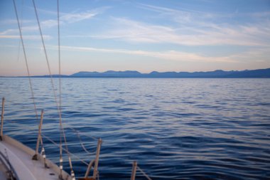 Günbatımında bir yelkenliden Britanya-Kolombiya kıyı şeridini büyüleyici bir şekilde görmek. Gürcistan 'da Günışığı Sahili' ne doğru yol alıyoruz.