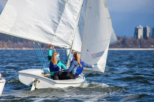 A collegiate women\'s sailing team competes in a regatta in Vancouver, British-Columbia with other Universities sailing the FJ Class