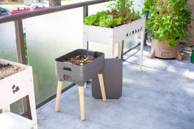 Vermigübreleme sistemi (solucan gübresi) bir apartmanın balkonunda diğer teras çiftçileriyle birlikte bulunur. Solucanlar yiyecek artıklarını yerler ve gübre olarak kullanmak için solucan atıkları ve solucan çayı üretirler. Atıkları yeniden yönlendir.