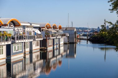 Mosquito Creek Marina, Kuzey Vancouver, British-Columbia 'daki rıhtımlarda yüzen sevimli yüzen yüzen yüzen yüzen yüzen yüzen tekneler. Bu alternatif konut, zorlu bir konut piyasasıyla popülerlik kazanıyor.