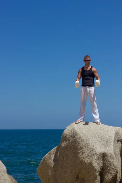 Man athlete trains, practicing, on the beach — ストック写真