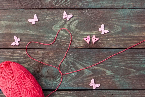 Costura y punto. Tejer sobre un fondo de madera. Botones en forma de corazones y mariposas. El amor postal. Hobby. . — Foto de Stock