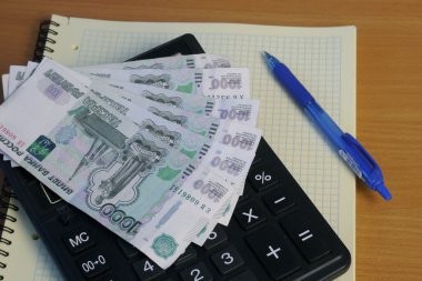 Hesap makinesi ve para masada.