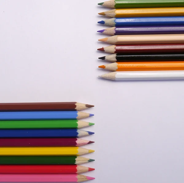 Crayons de couleur affûtés se trouvent en face de l'autre Image En Vente