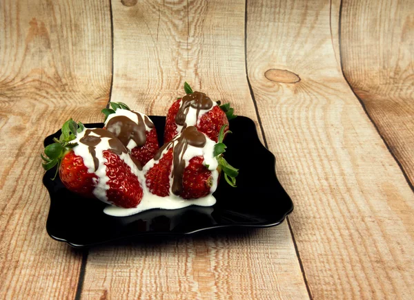 Photo of fresh strawberries with cream and chocolate on wooden t — Stock Photo, Image
