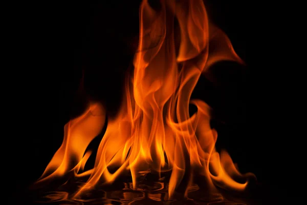 Röda flammor av eld på svart bakgrund — Stockfoto