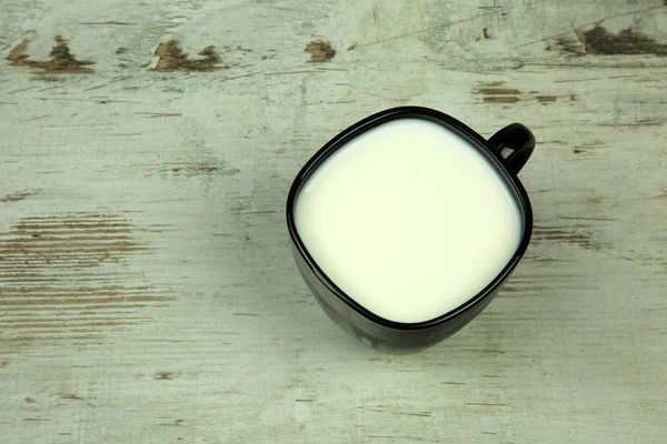 Een beker melk op oude houten vintage tafel — Stockfoto