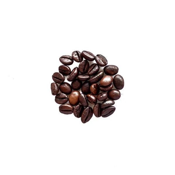 Beyaz arka planda kaotik bir şekilde duran kahve çekirdekleri..