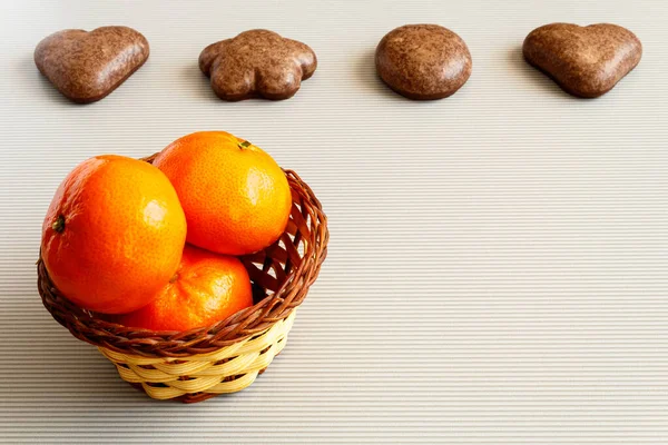 Sepette mandalinalar ve arka planda zencefilli kurabiyeler..