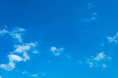 Beyaz bulutlar açık mavi gökyüzüne karşı.